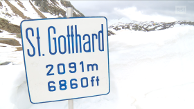 Distesa innevata in ambiente alpino ancora copert; cartello St. Gotthard 2091 mslm
