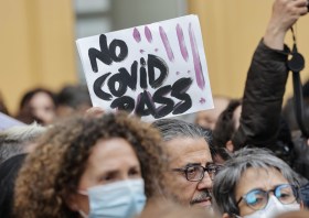Un cartello con la scritta no Covid pass esibito durante una manifestazione.