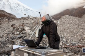 donna con un computer portatile su un ghiacciaio ricoperto di detriti