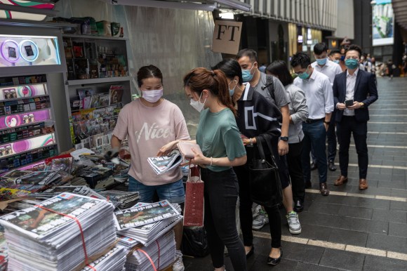 Persone in fila in attesa di acquistare il giornale