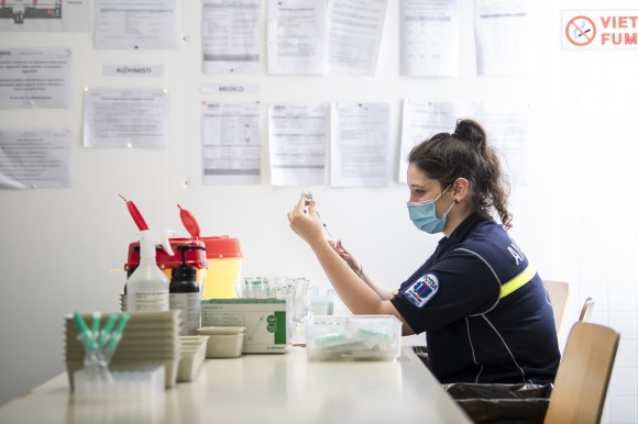 Una giovane paramedico prepara le dosi di vaccino da inoculare.