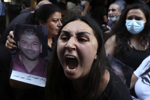 Donna che urla tenendo in mano la foto di un familiare morto nell esplosione di Beirut