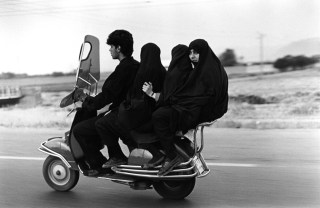 Young man, three veiled girls in a four-seater Vespa.