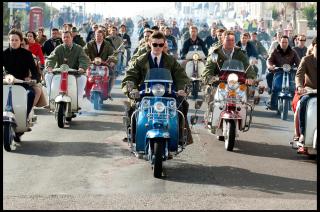 A crowd of people riding Vespa s