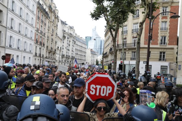Una folla per le vie di Parigi contro il certificato sanitario imposto dal governo.
