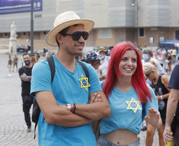 due persone che indossano una stella di davide con la scritta no vax