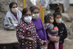 quattro donne peruviane con mascherina una di loro tiene una bambina in braccio