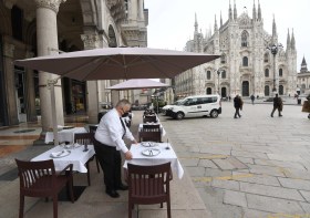 Cameriere prepara i tavoli del suo ristorante in Piazza Duomo a Milano.