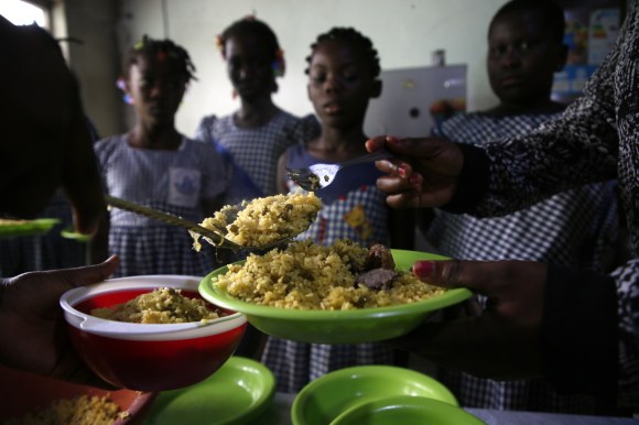 Una maestra distribuisce cibo alle allieve in una scuola di Adidjan in Costa d Avorio.