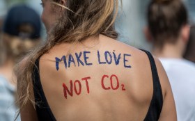 persona con scritta sulla schiena make love not co2