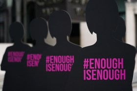 sagome nere di donne con scritta in rosa #enoughisenough
