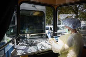 Un paramedico prepara una siringa per il vaccino su un tram di Zurigo.