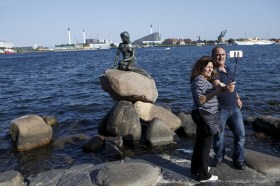 Turisti si fanno una fotografia davanti alla famosa Sirenetta.