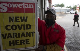 Un uomo vicino al lancio del giornale Sowetan con scritto New Covid Variant here