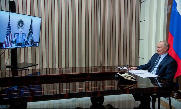 Putin seduto a una scrivania con televisione