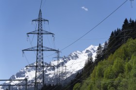 palo dell elettricità davanti a montagna innevata e cielo azzurro