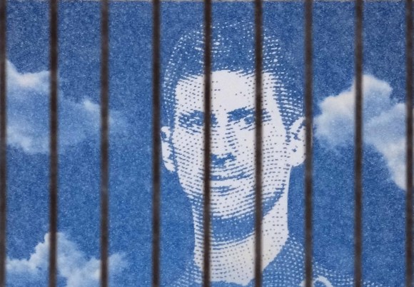 Una foto di Djokovic dietro a una barriera: sembra che il tennista sia in prigione.