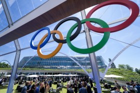 La sede del CIO a Losanna con in primo piano i cinque anelli olimpici.