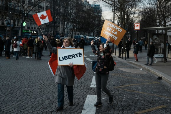 Due donne in centro Parigi con cartelli inneggianti alla libertà.