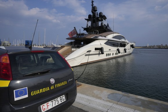 auto guardia di finanza davanti a yacht di lusso ormeggiato