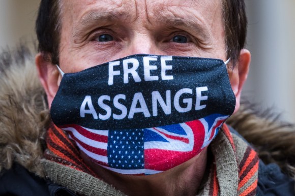 donna con mascherina con la scritta Assange libero