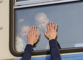 mani appoggiate su un finestrino di un treno