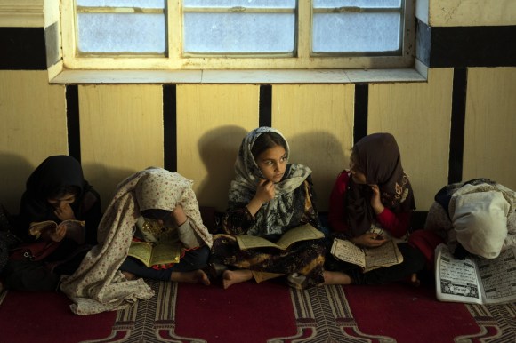 bambine con velo (5) leggono libri scritti in arabo sedute per terra