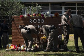 Poliziotti mettono i fiori davanti alla scuola dove si è tenuta la strage