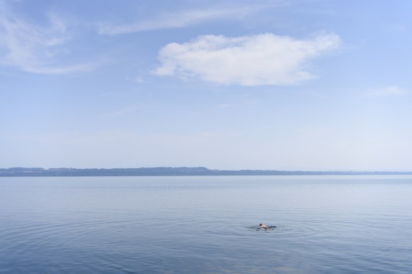 Bagnante nuota in prossimità della spiaggia di Jeunes-Rives a Neuchatel.