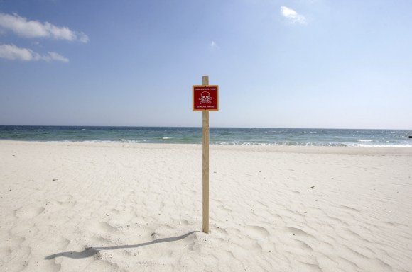 Un cartello con pericolo di morte piantato nelle sabbie della spiaggia di Odessa.