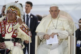 papa francesco seduto accanto a un capotribù indiano