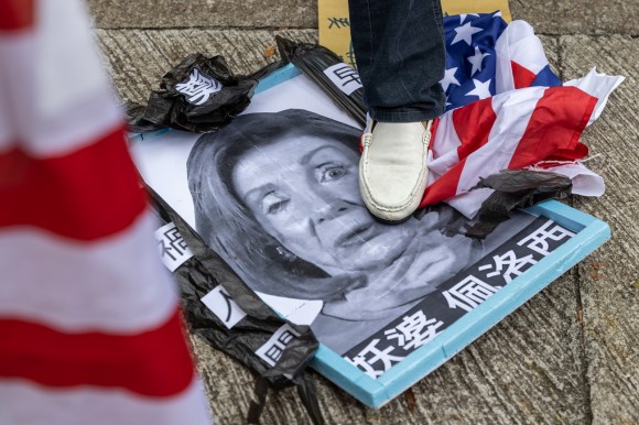 Un immagine di Nancy Pelosi calpestata insieme a banidere svizzere.