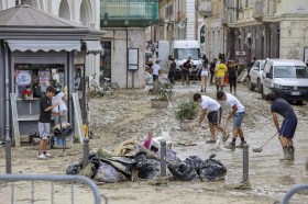 RAgai cercano di pulire le strade piene di fango a Senigallia