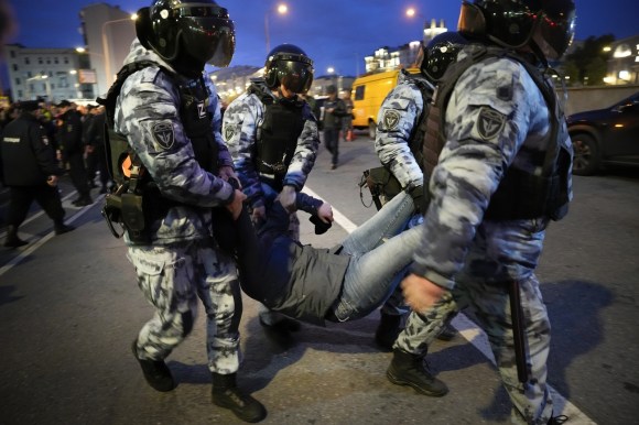 Un dimostrante fermato da quattro militari nel centro di Mosca.