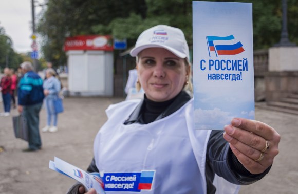 Una volontaria che distribuisce voantini con la scritta con la Russia sempre