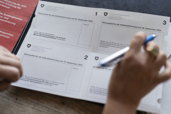 Una persona compila la scheda elettorale per la votazione del 25 settembre.
