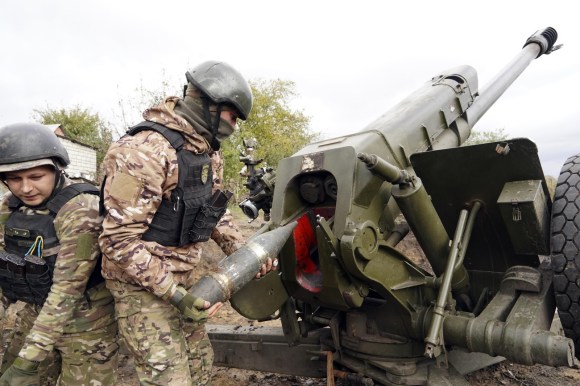 Soldati ucraini caricano un cannone.