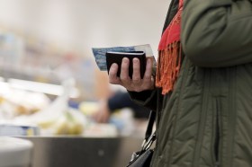 Una donna con in mano un portaflio e una banconota da 100 franchi.