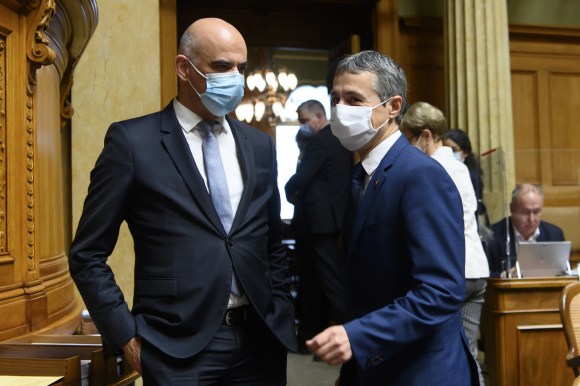 Due uomini in giacca e cravatta con mascherine chirurgiche