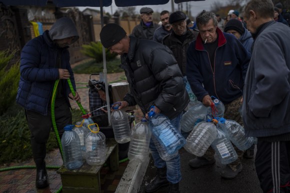 persone riempiono bottiglie di plastica con acqua