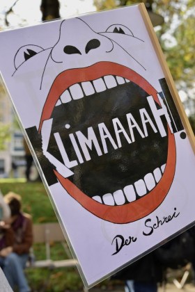 cartello con disegno di bocca aperta che grica la parola KLIMAAAAAAAH!