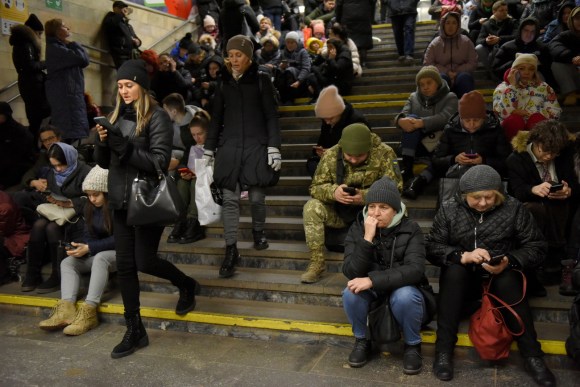 numerose persone sedute su scalinata di metro di kiev