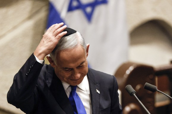 uomo con capelli grigi tiene mano destra su kippa ebraica nera che porta sulla testa