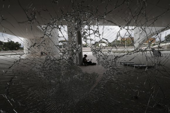 Person sits behind shattered window of Brail s Congress building