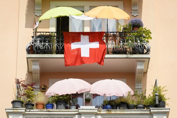 Bandiera svizzera fuori dal balcone di un appartamento.