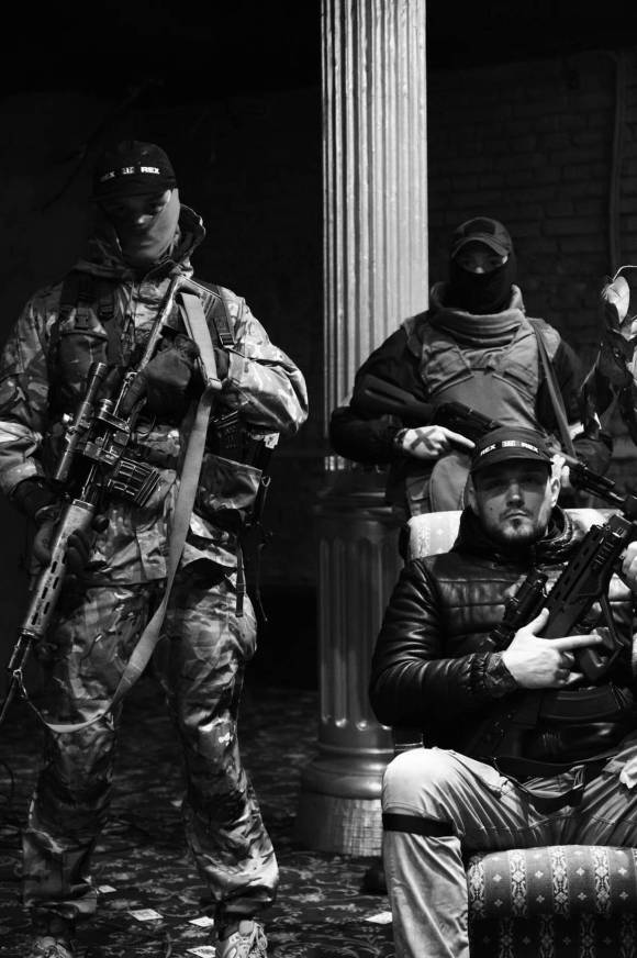 immagine in bianco e nero di uomini armati in tuta mimetica
