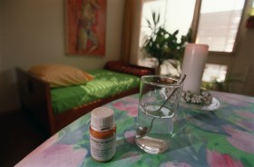 bicchiere d acqua e flacone di farmaci su un tavolo