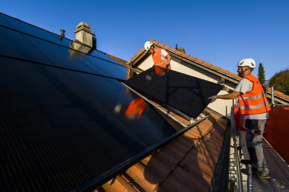 operai installano pannelli solari su un tetto