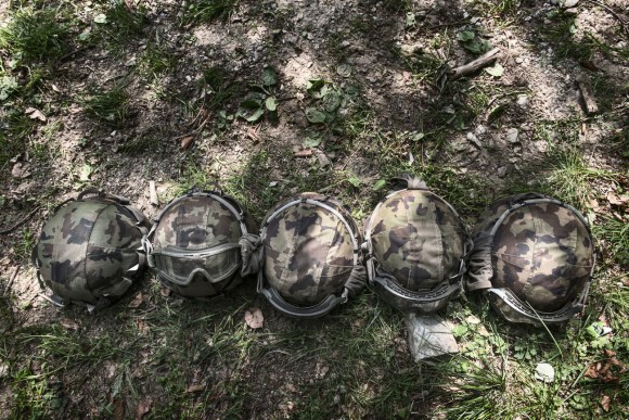 cinque caschi militari in fila appoggiati sull erba