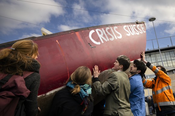 I manifestanti con una barca chiamata Crisis Suisse